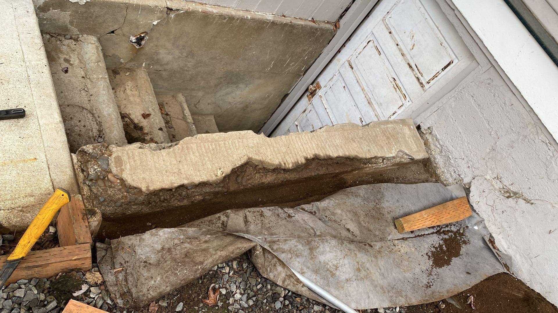 Broken and crumbling concrete steps at a basement entry before repair