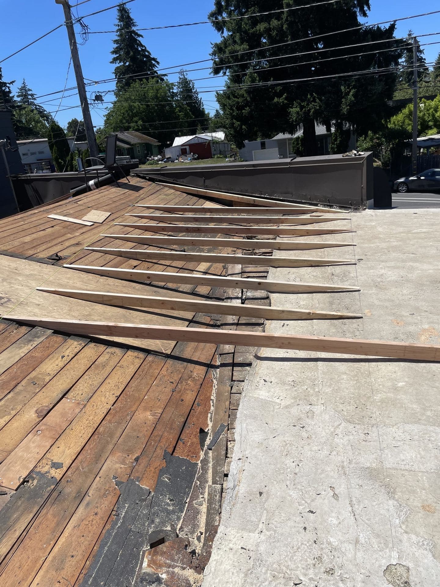 Slope framing lumber and plywood sheathing being laid over old roof decking