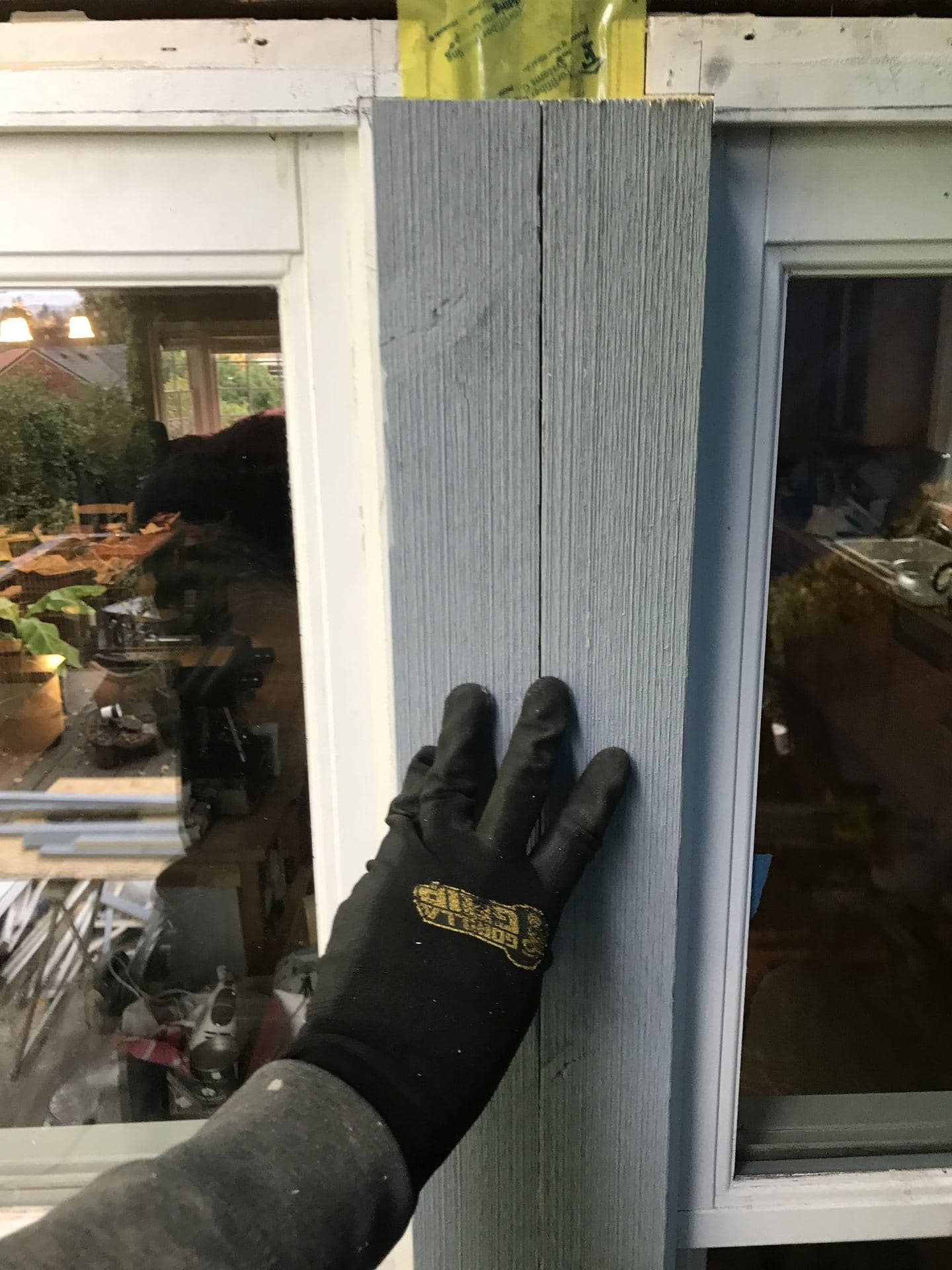 Fiber-cement siding board being set between window and door trim