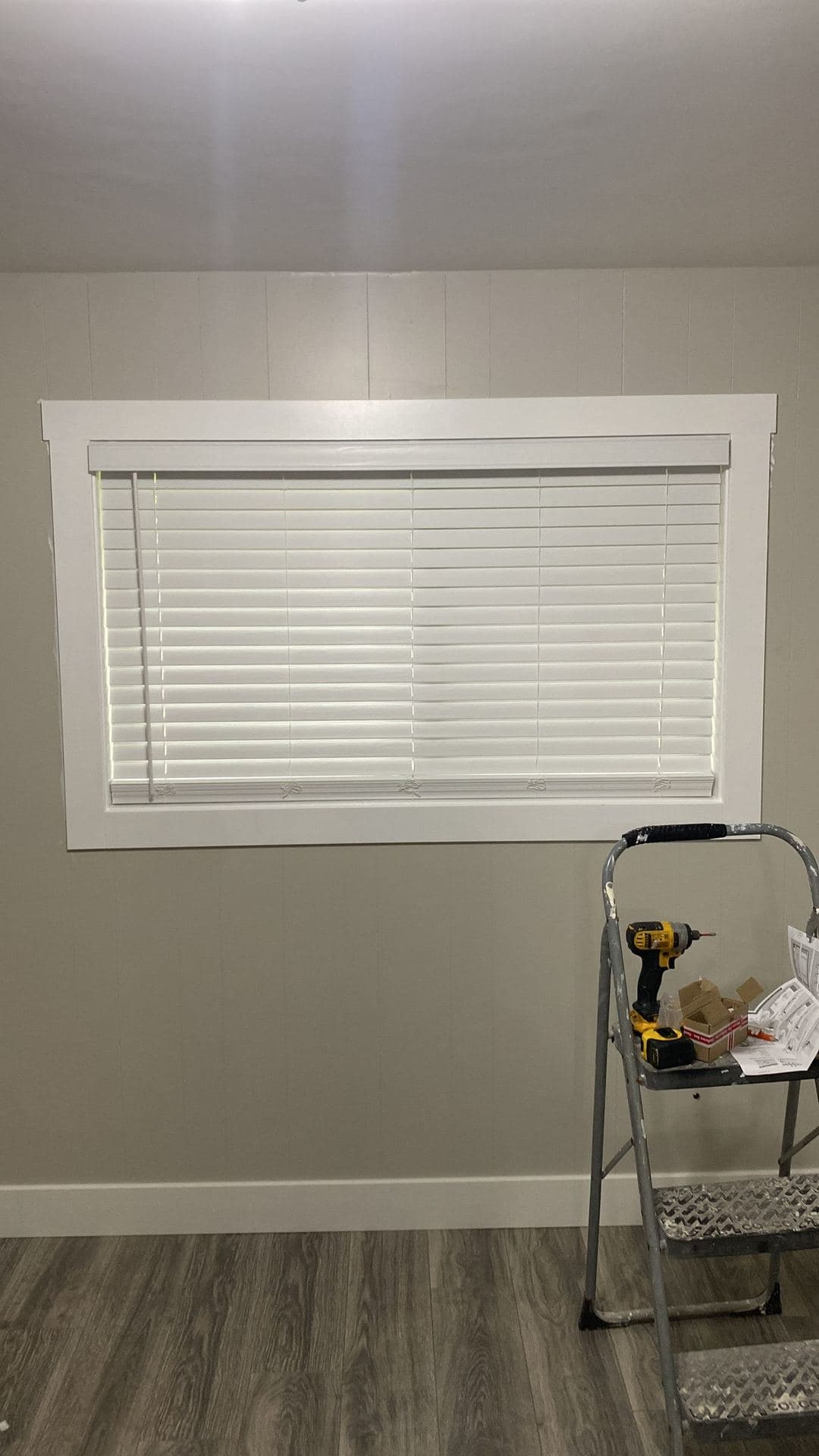 Finished interior window with white craftsman-style trim and blinds